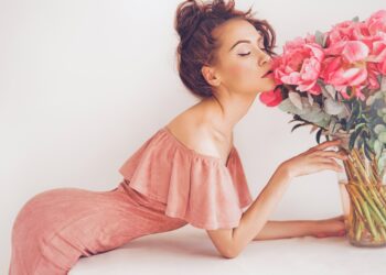 Lifestyle photo of beautiful young woman with pink peonies. Bouquet as gift. Emotions of happiness and joy. Valentines day. Mothers day